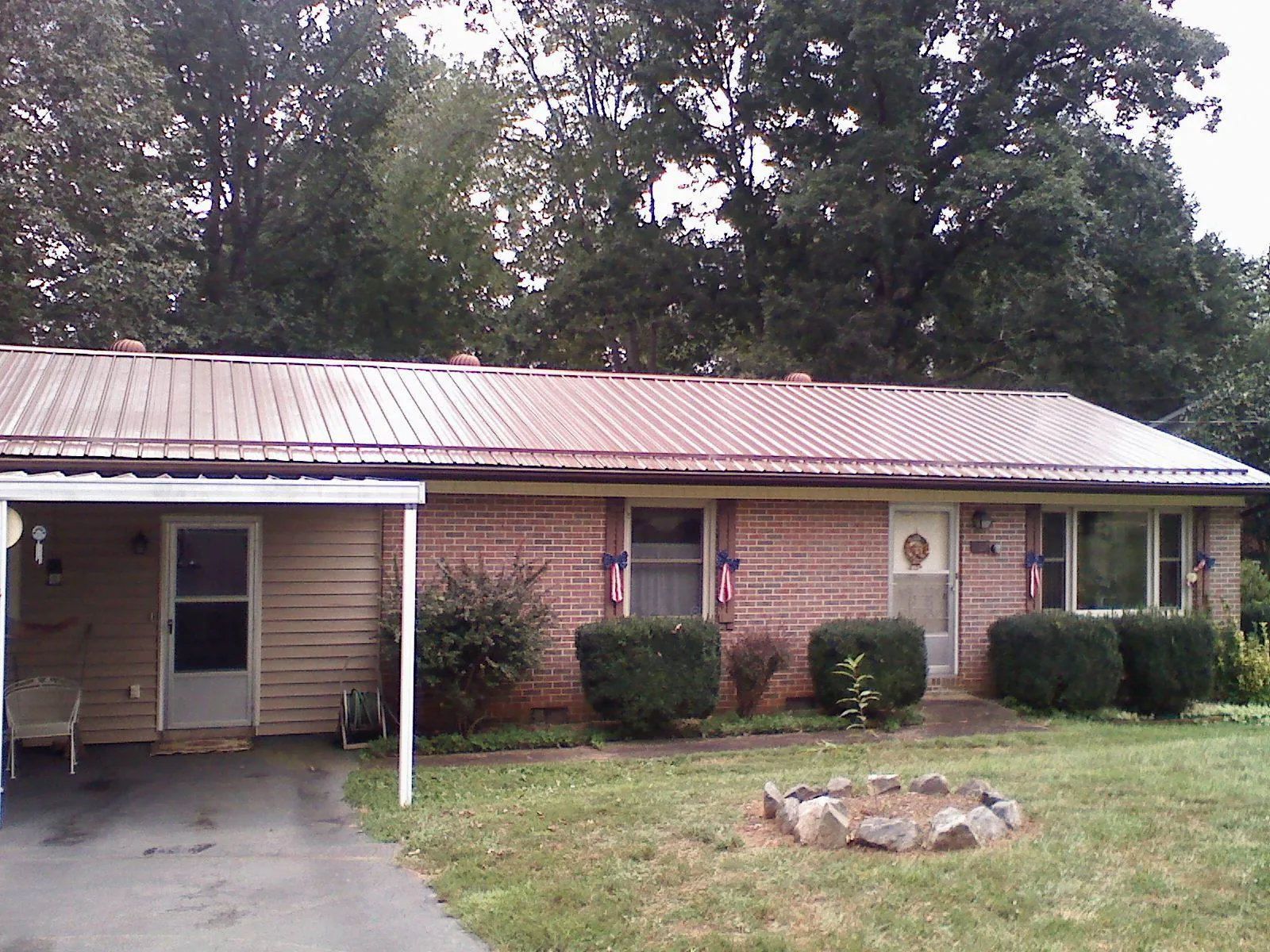 Bronze metal roof and carport on a brick ranch home — Roof Repair work by our crew in Orem